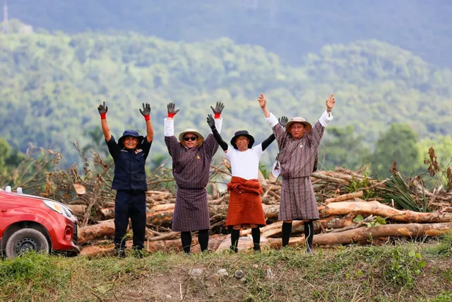 Officials in traditional dress greeting workers on cleared ground at the site